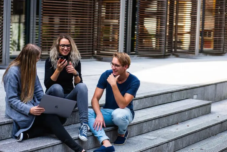 Equipo de trabajo conversando de forma distendida al aire libre, ejemplo de cómo los mandos pueden fomentar el bienestar creando espacios informales de conexión
