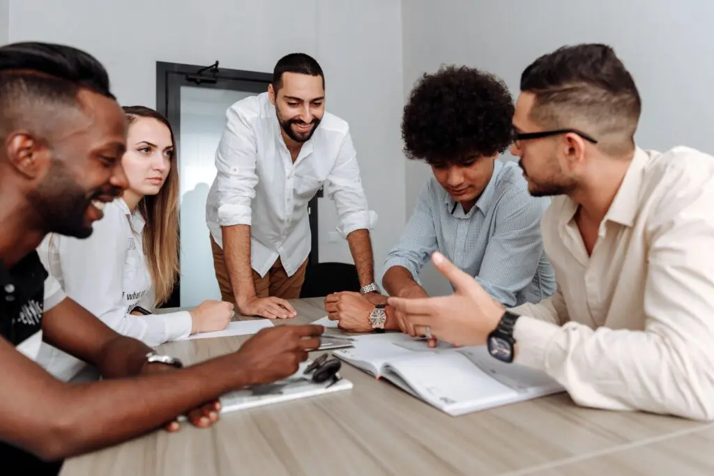 Equipo diverso colaborando en una reunión de trabajo, reflejando el plan de desarrollo de habilidades para fomentar el bienestar y el compromiso